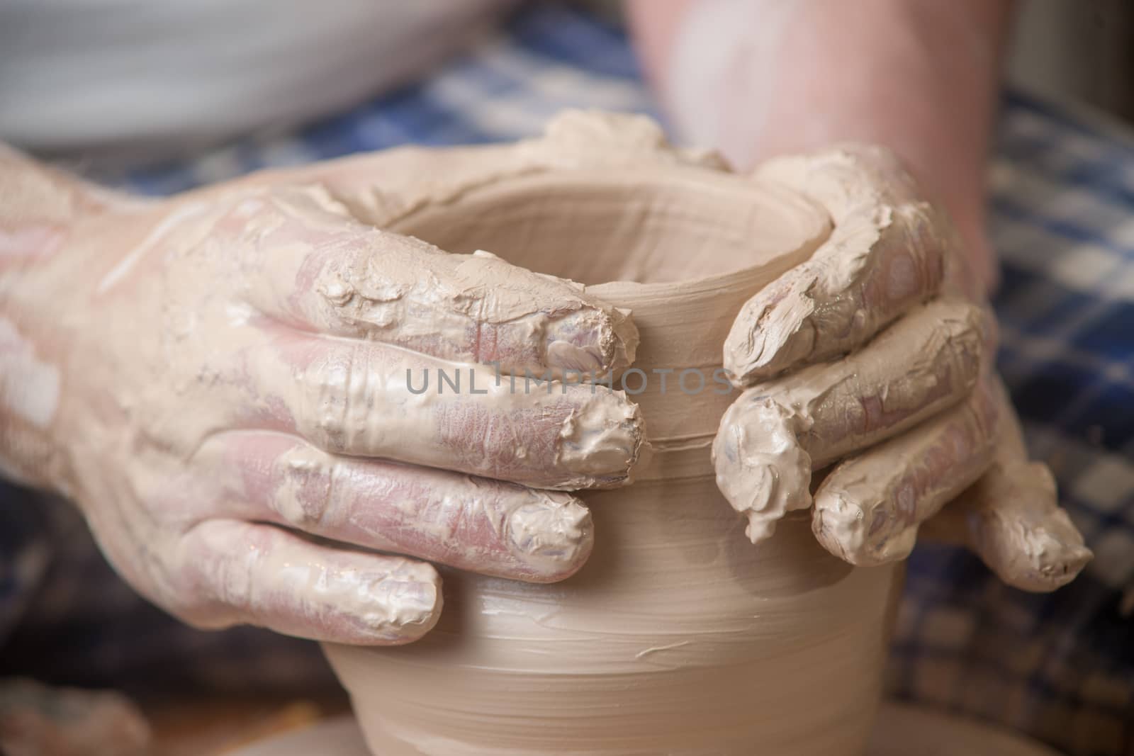 Hands of a potter, creating an earthen jar on the circle