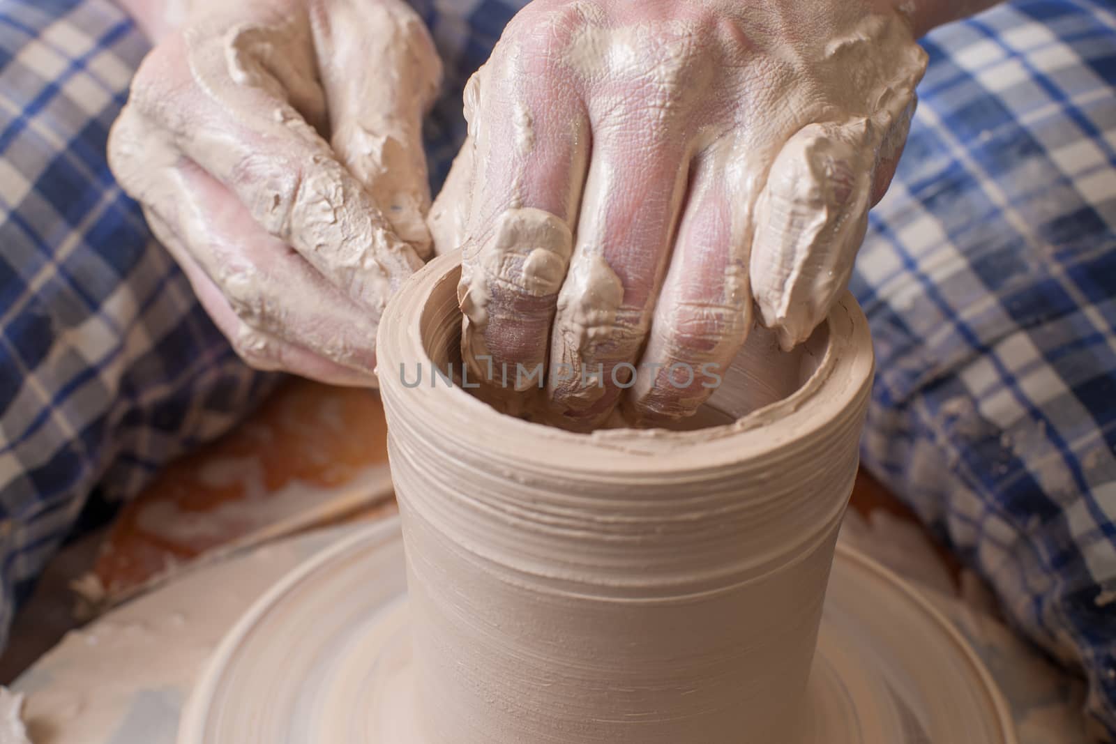 Hands of a potter, creating an earthen jar on the circle