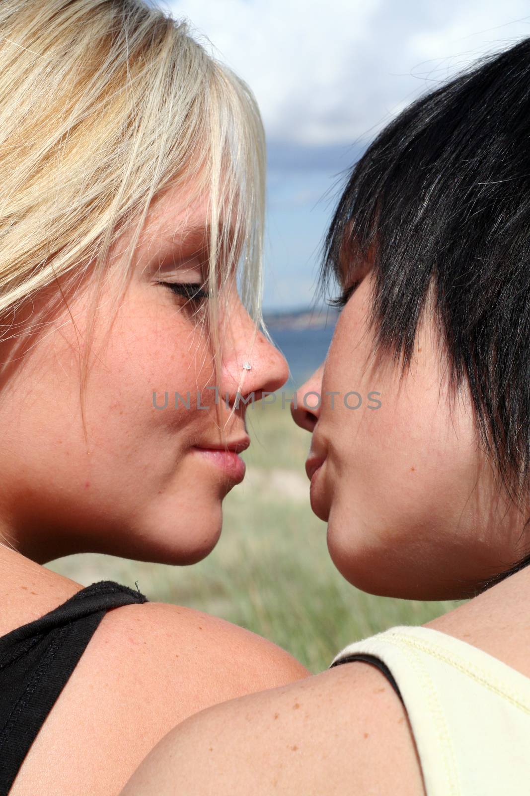 two Young women at the Beach flirting and kissing