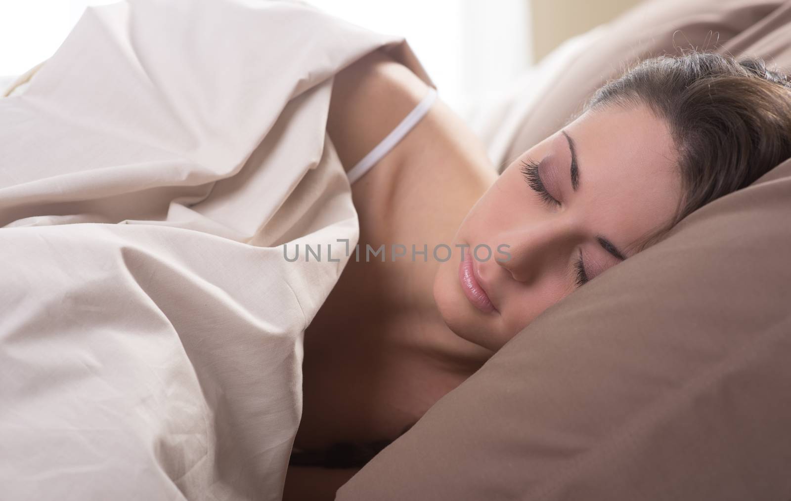 Young beautiful woman sleeping comfortably on bed