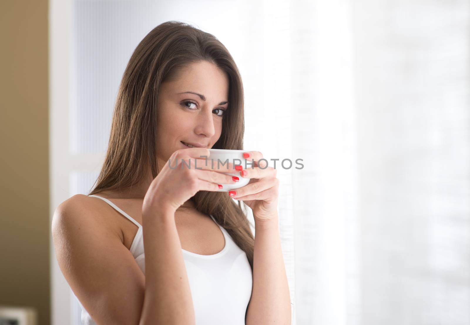 Beautiful woman with cup of coffee looking at camera