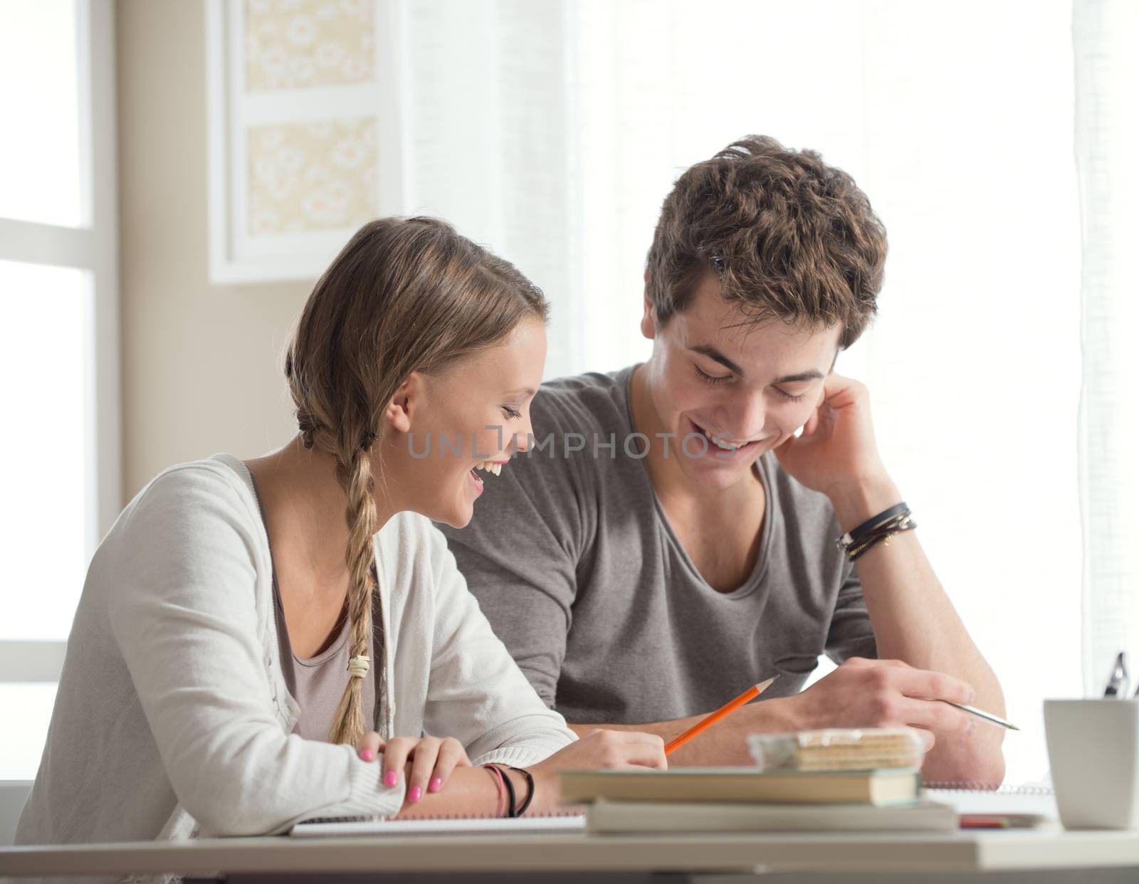 Teen boy and girl sitting together and studying 