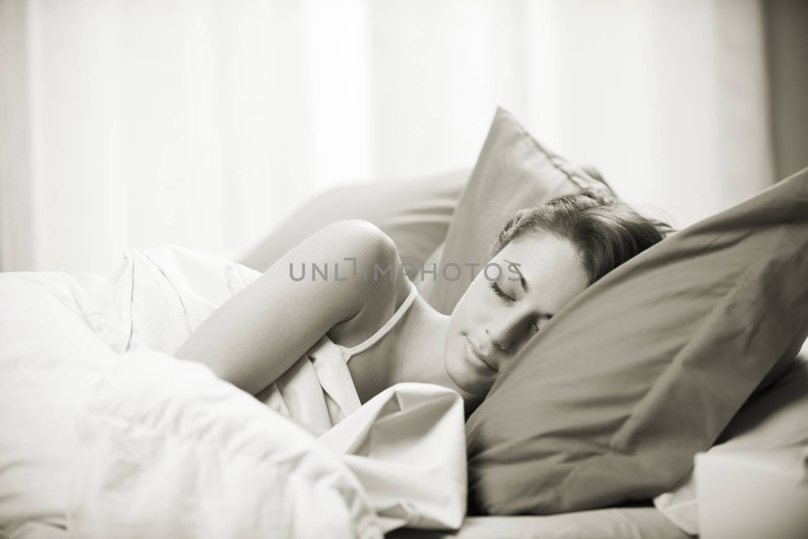 Young beautiful woman sleeping comfortably on bed