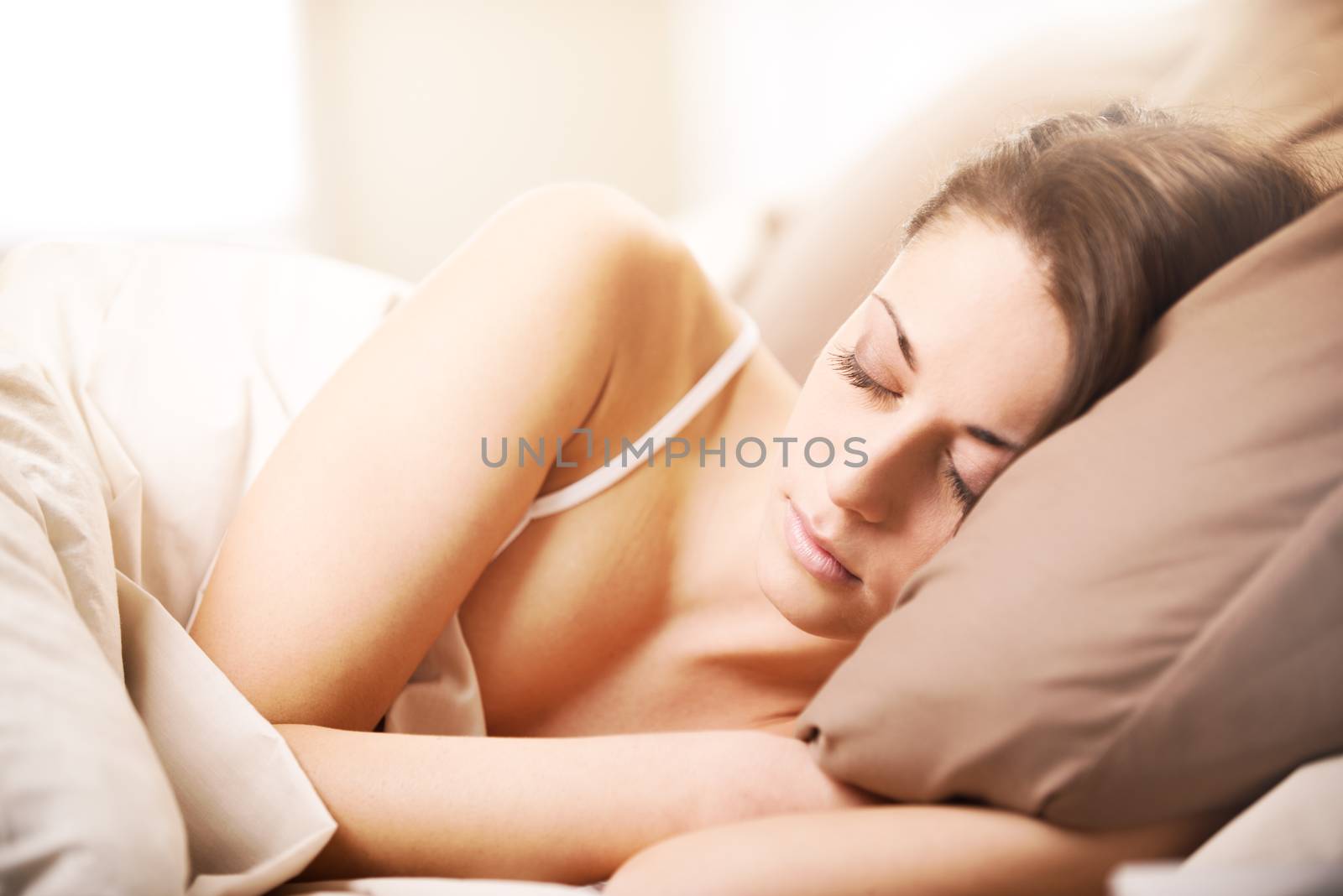 Young beautiful woman sleeping comfortably on bed