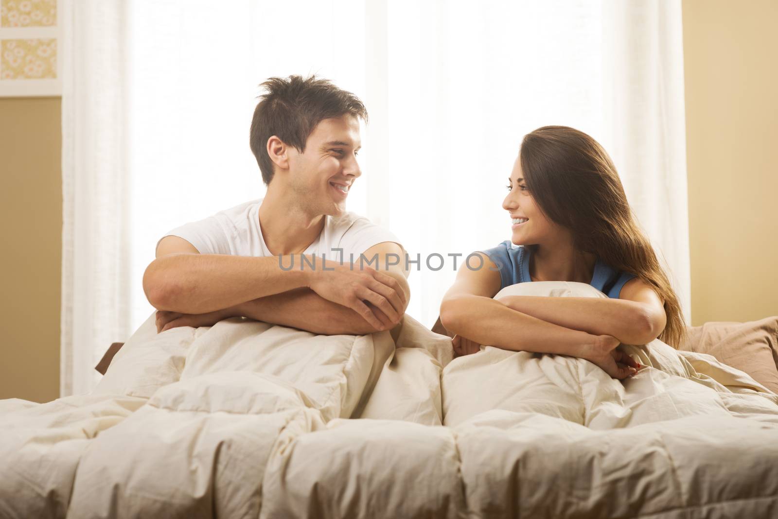 Portrait of a happy young couple lying on bed
