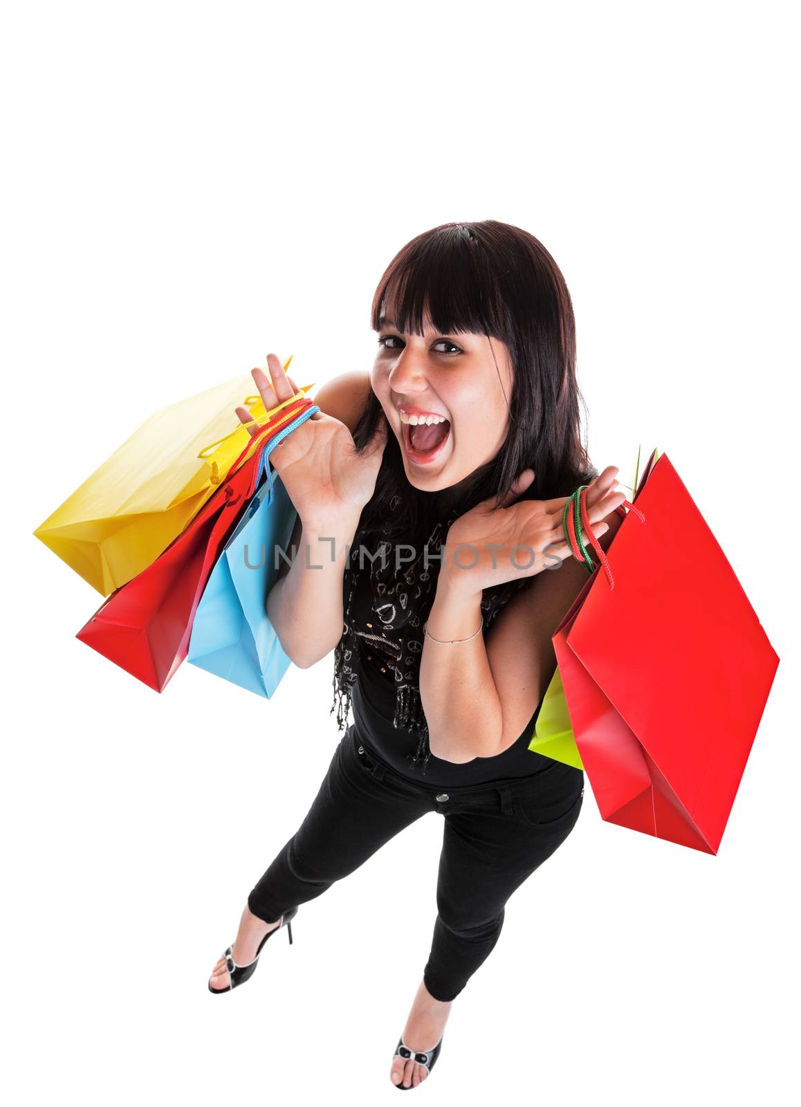 Smiling young woman, dressed Indie style, with shopping bags.  She is happy because of all the great sales!  Shot on white background with wide angle.