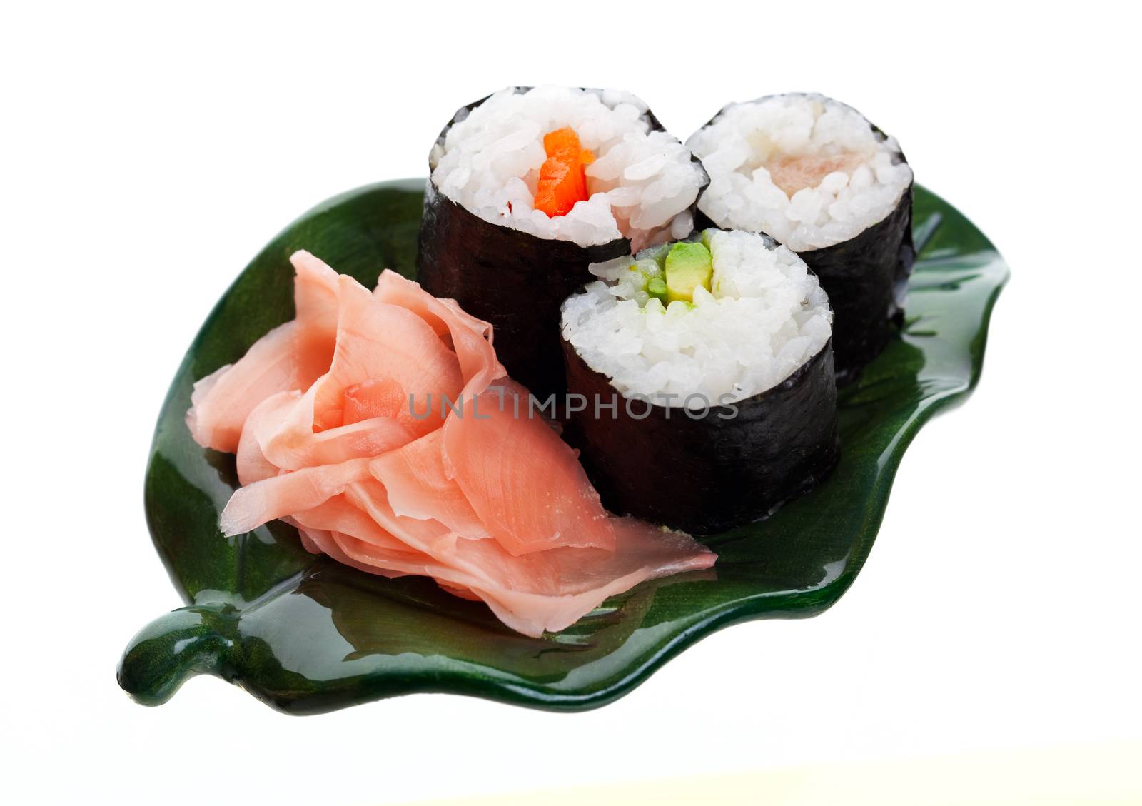 Three kinds of sushi with ginger on a leaf shaped plate.  Shot on white background.