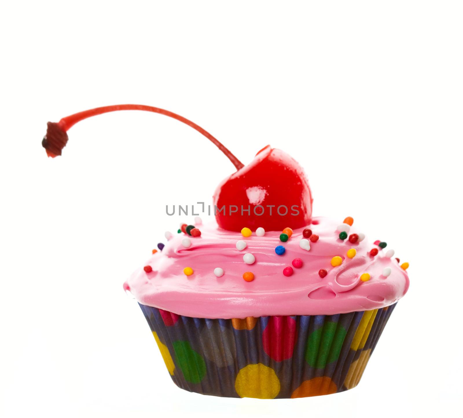 A wide angle view of a delectable pink cherry cupcake.  Shot on white background.