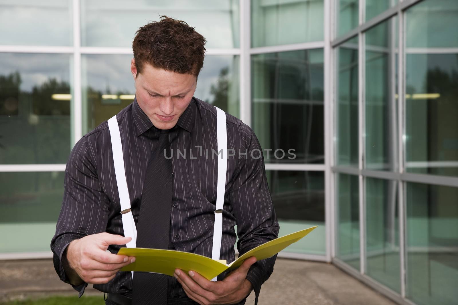 A businessman concentrating on the paperwork in his folder.
