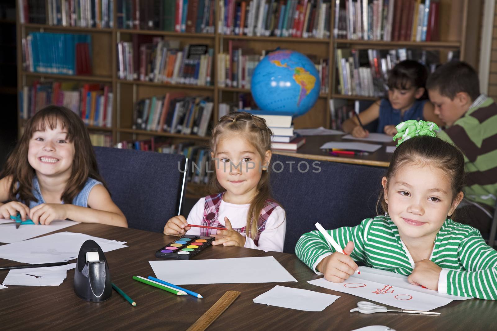 Elementary students in a school library doing art projects.  