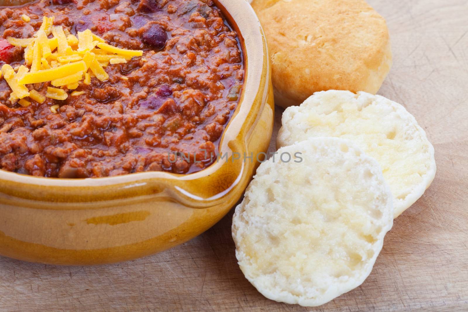 Chili Con Carne topped with shredded cheddar cheese, and served with hot buttered biscuits.