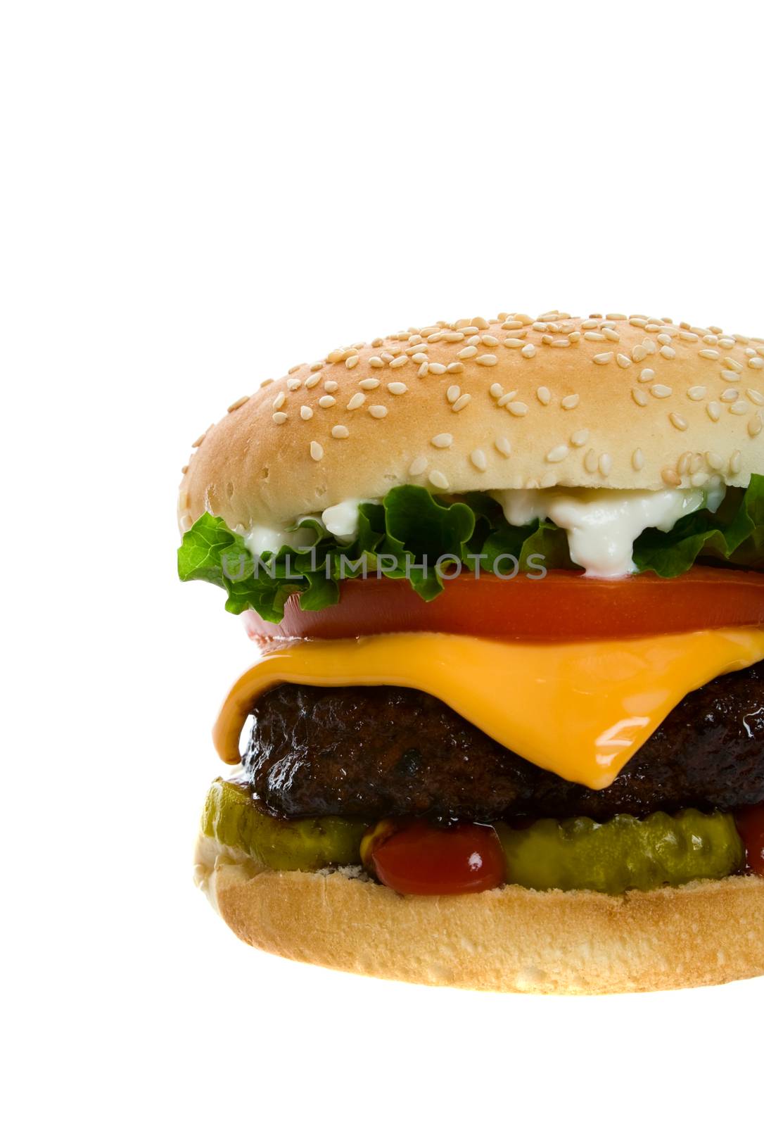 Juicy Angus beef burger topped with cheese, tomatoes & lettuce on a golden sesame seed bun.  Shot on white background.