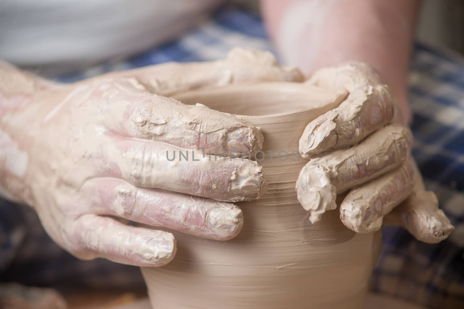 Hands of a potter, creating an earthen jar on the circle