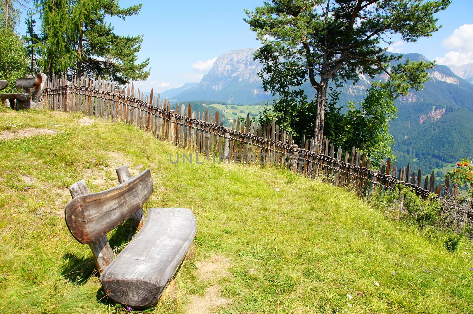 Holzbank in den Dolomiten mit Schlern im Hintergrund
