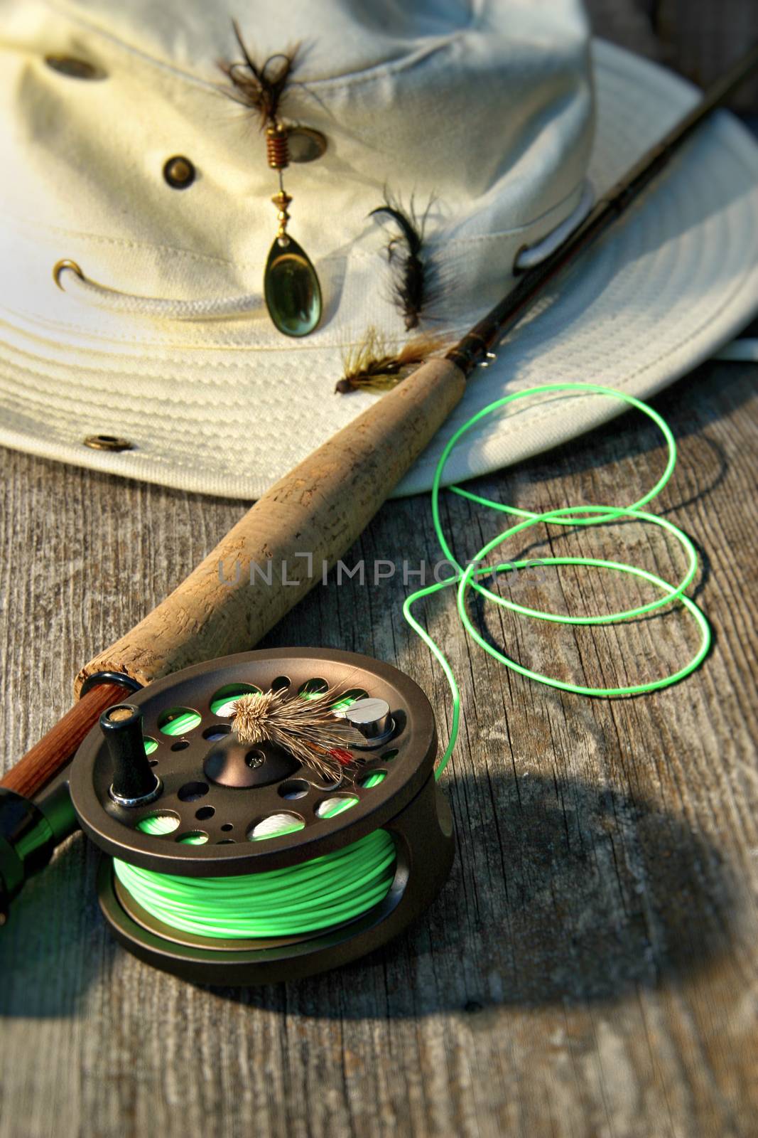 Close-up of fly-fishing reel and rod with canvas hat