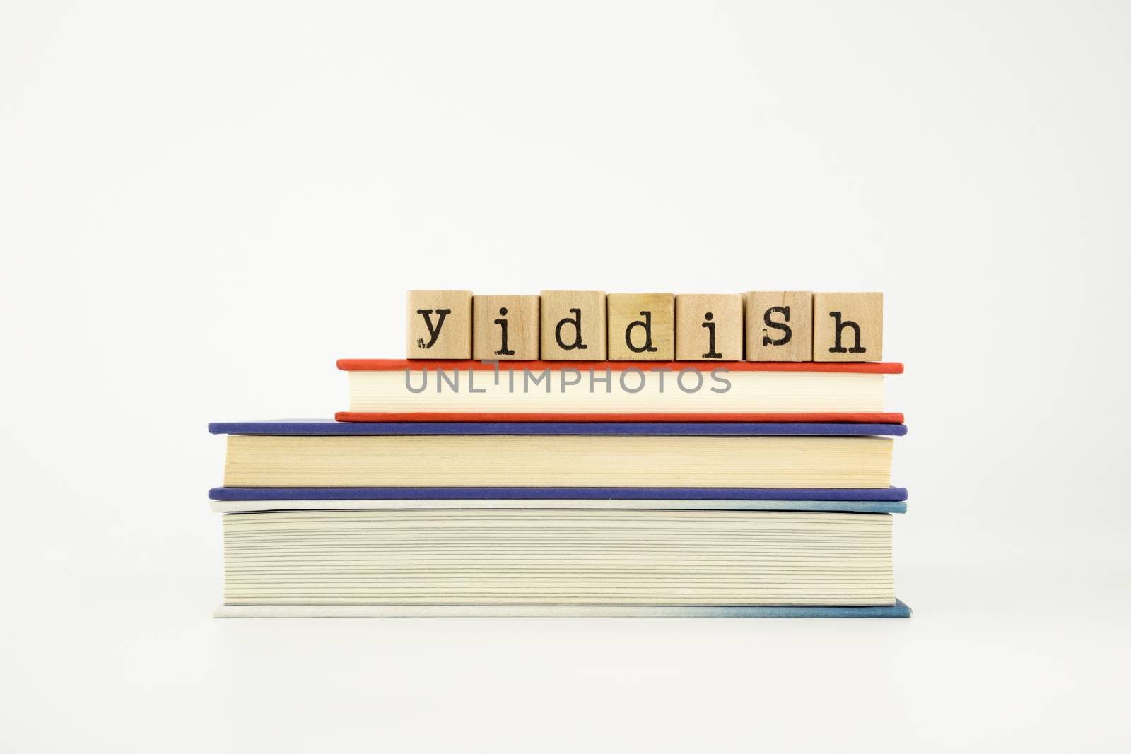 yiddish word on wood stamps stack on books, foreign language and translation concept