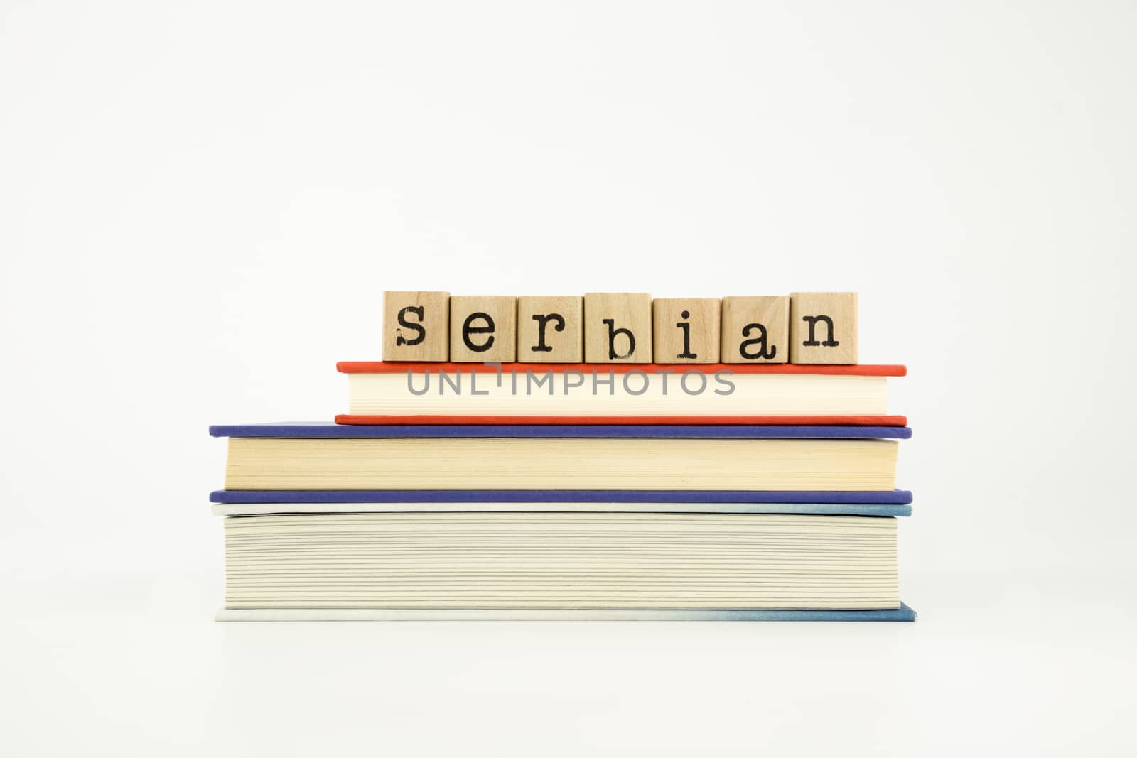 serbian word on wood stamps stack on books, foreign language and translation concept