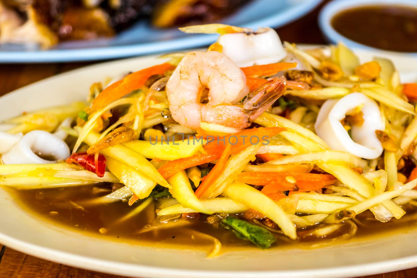 som tam,one of favorite thai menu that made from sliced papaya mixed with seafood