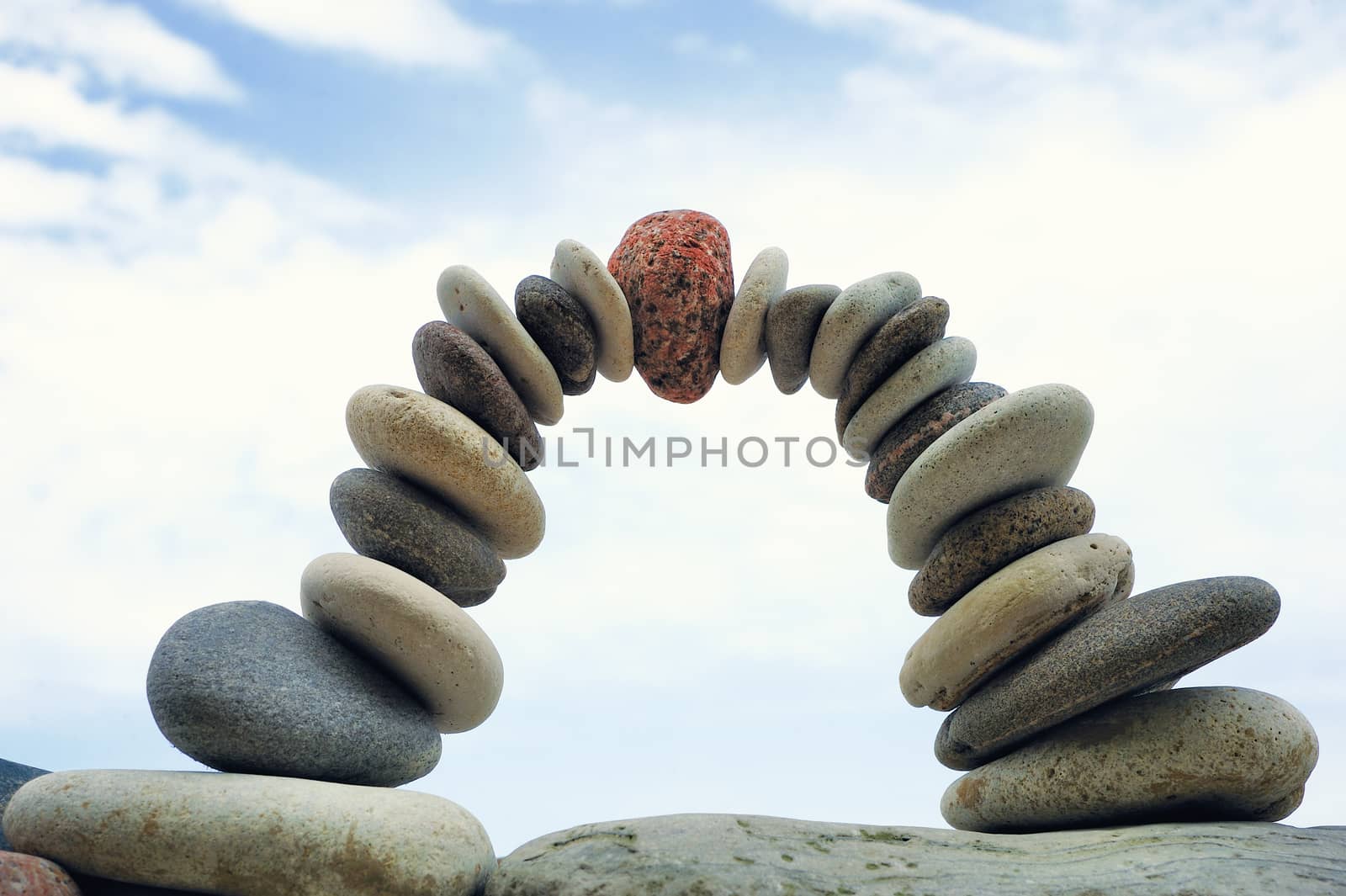 Balancing of white pebbles on sky background