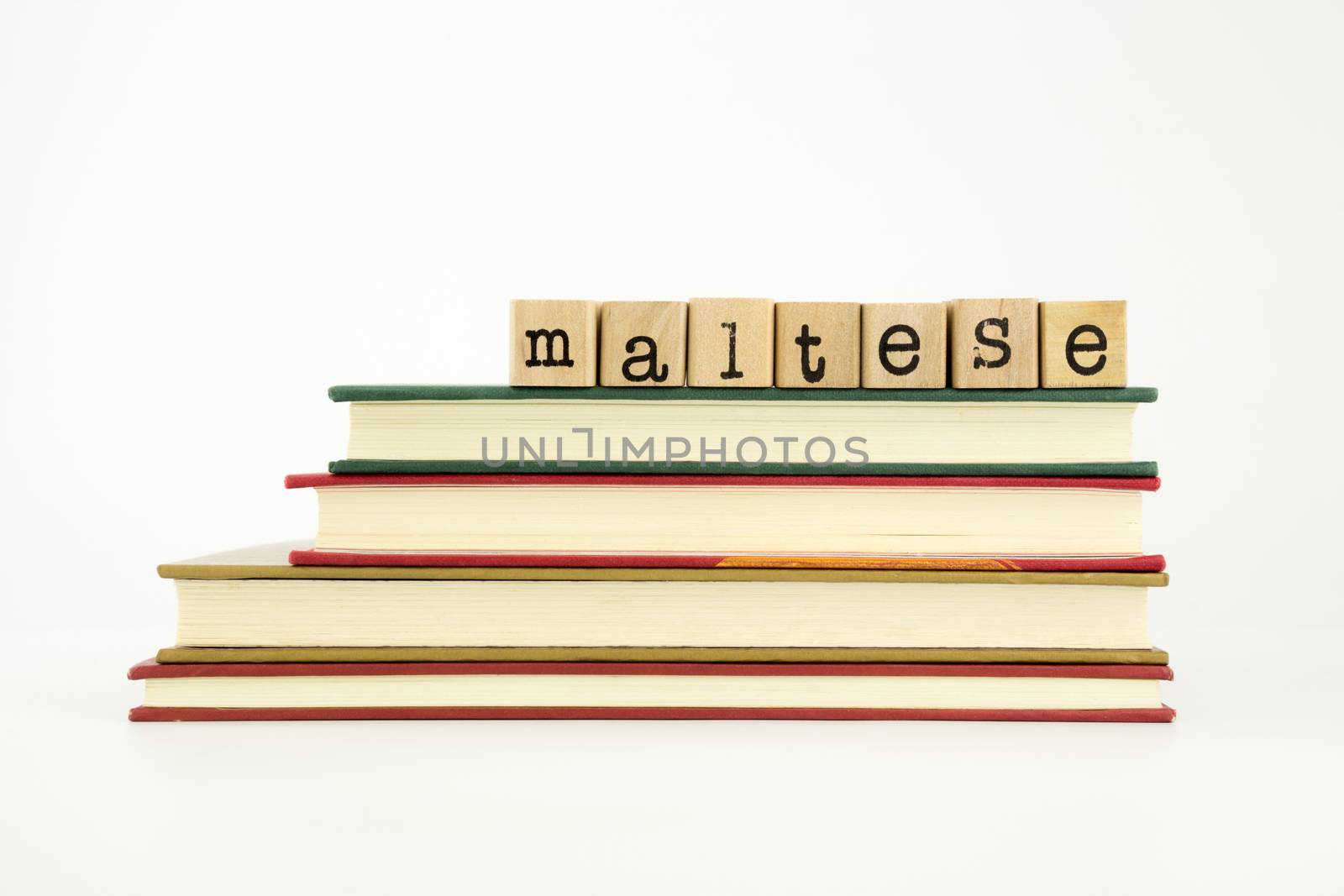 maltese word on wood stamps stack on books, foreign language and translation concept