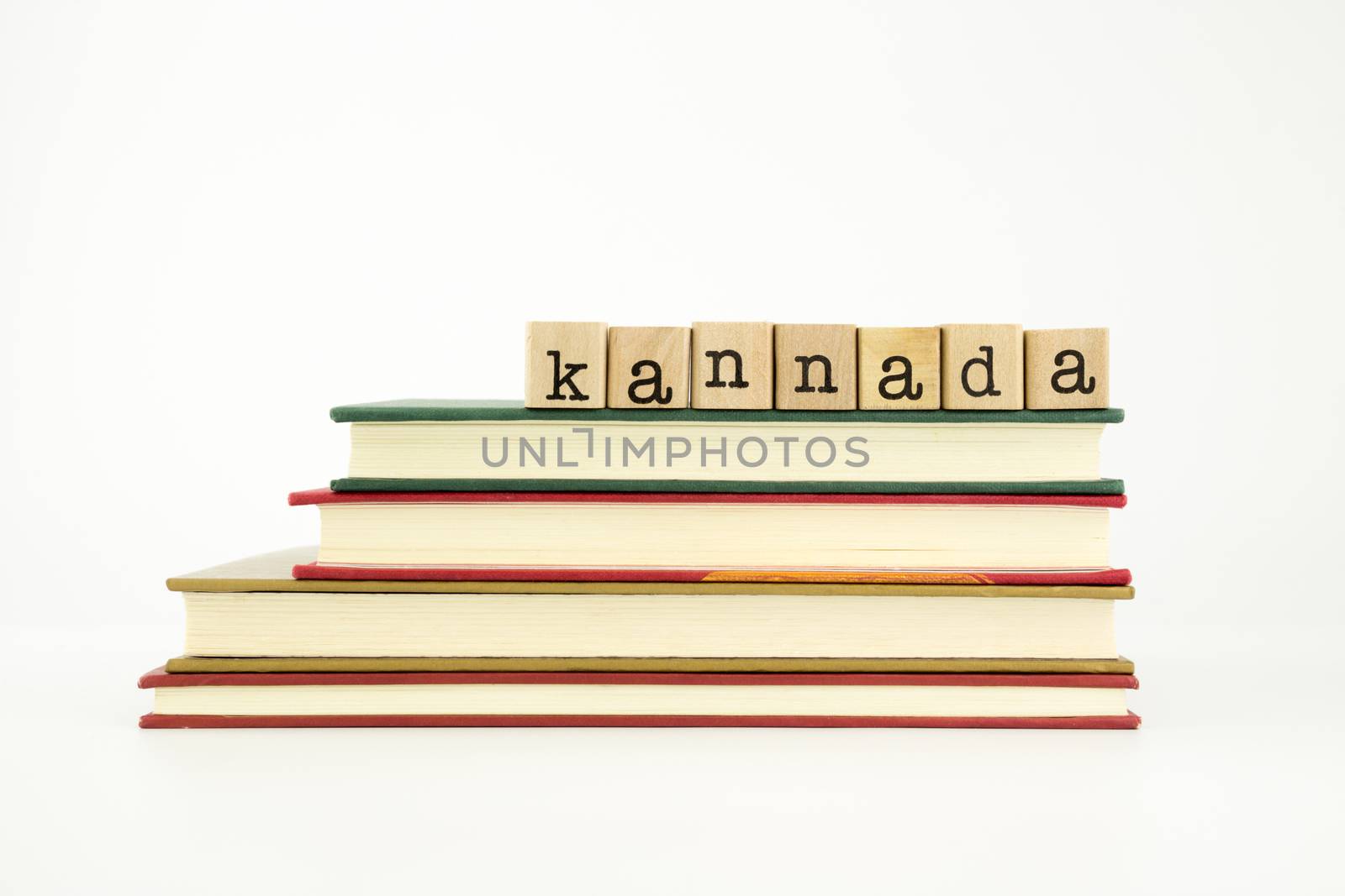 kannada word on wood stamps stack on books, foreign language and translation concept