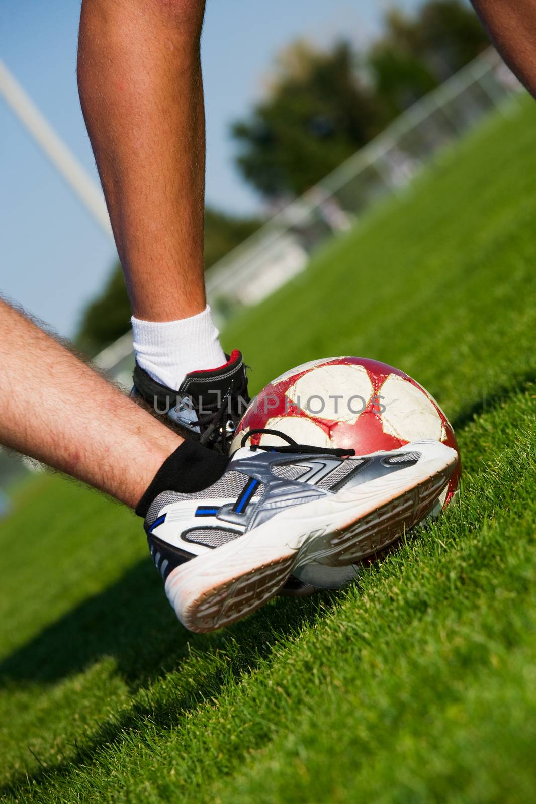 Two men's feet fighting for the soccer ball.