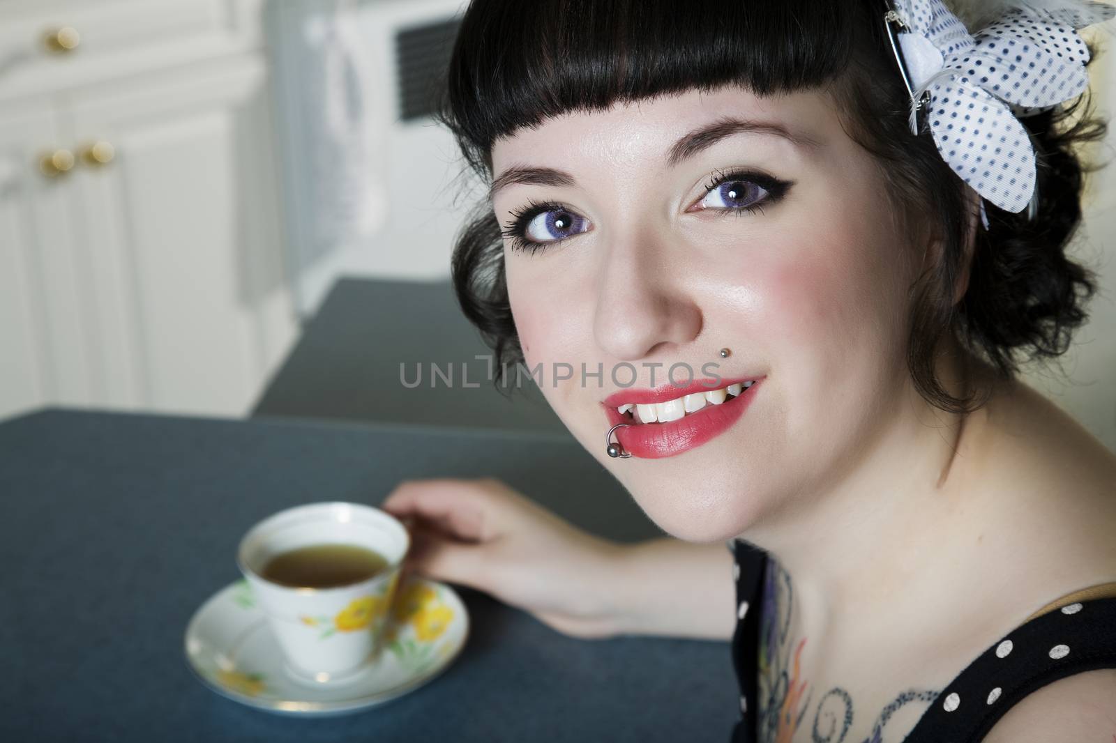 A rockabilly style girl enjoying tea.