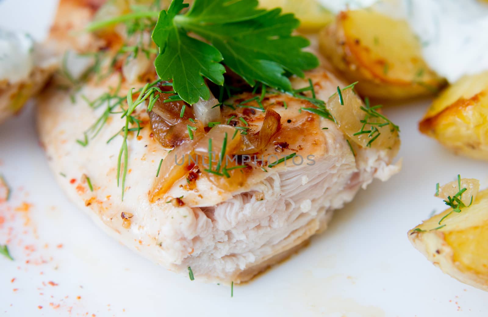 grilled chicken breast with roasted potatoes on white plate