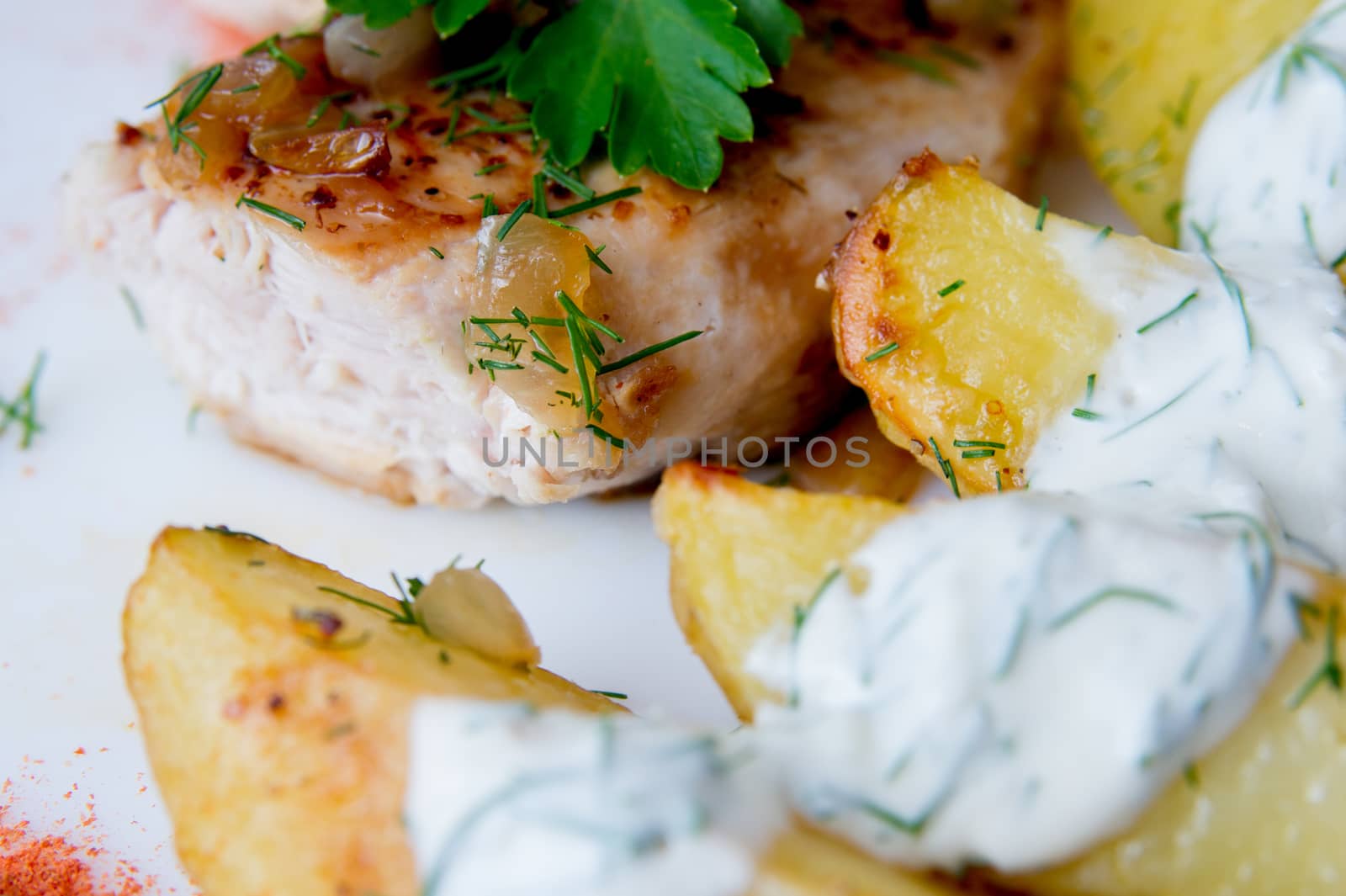 grilled chicken breast with roasted potatoes on white plate