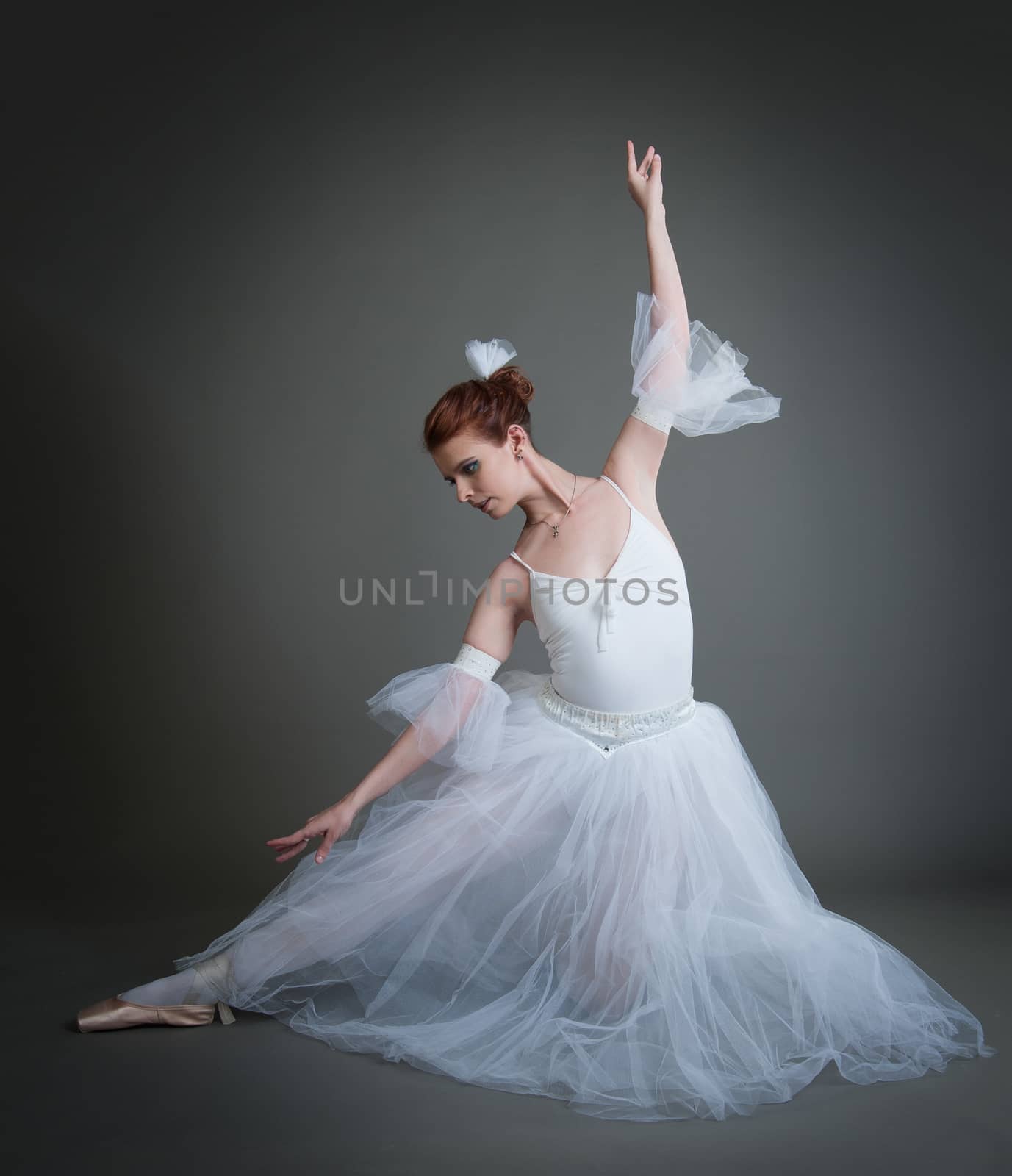 dancer in the white tutu dancing on a grey background