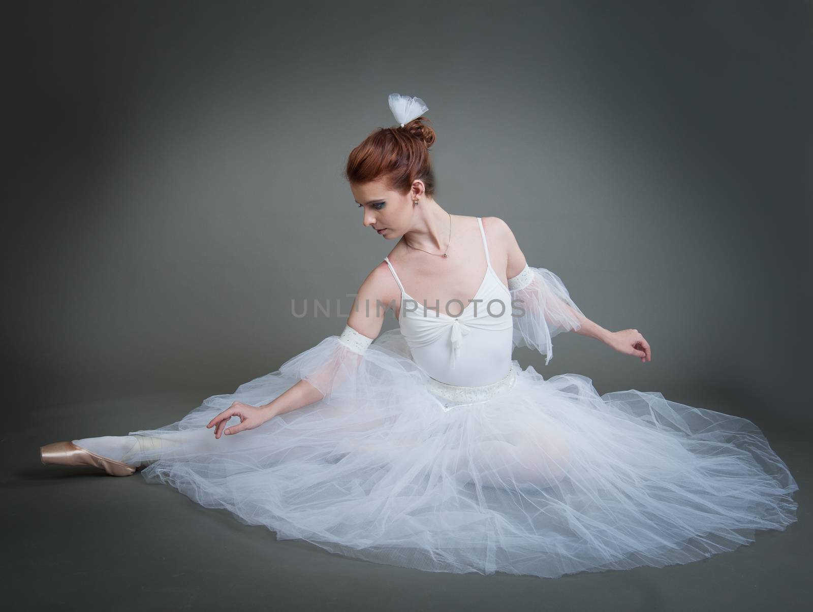 dancer in the white tutu dancing on a grey background