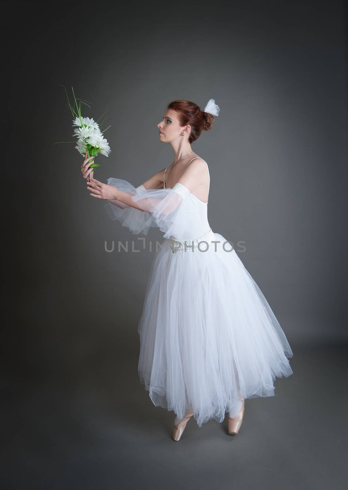 dancer in the white tutu dancing on a grey background