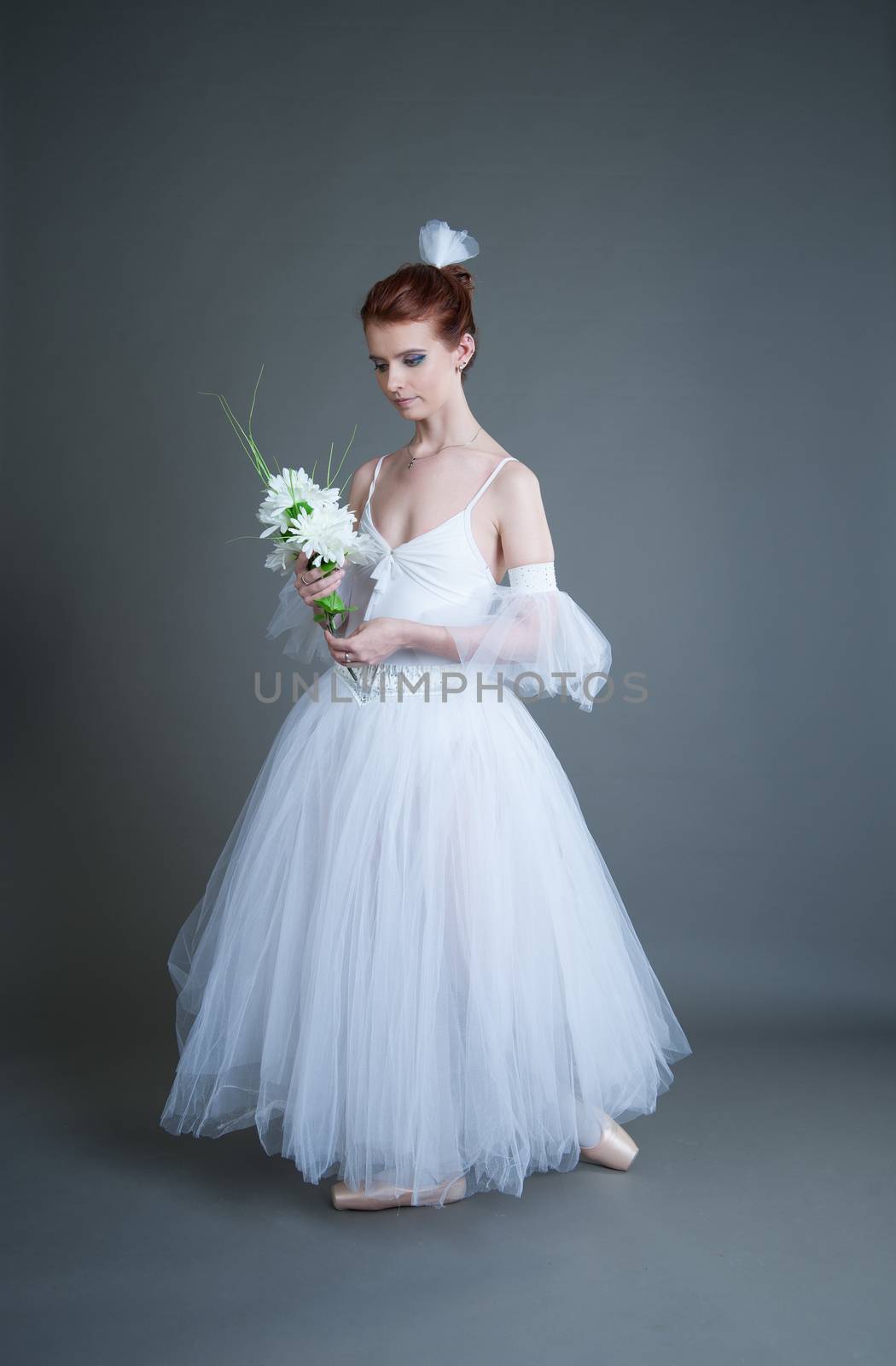 dancer in the white tutu dancing on a grey background