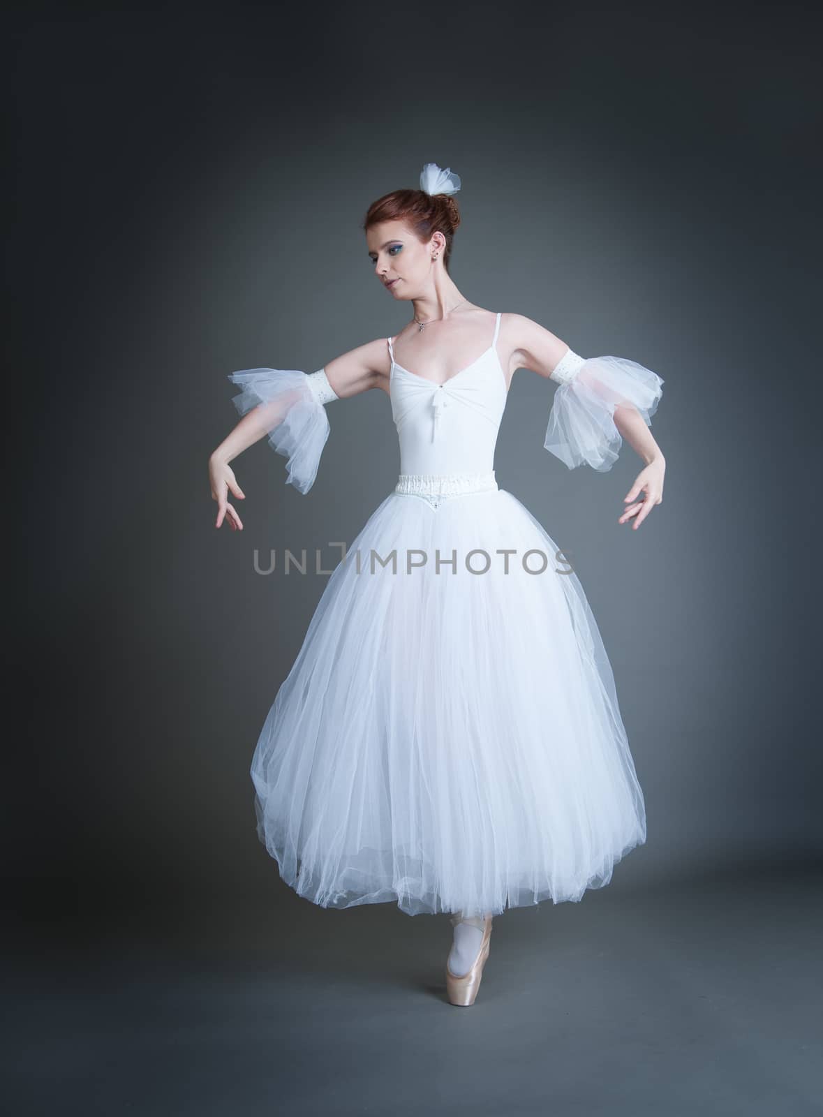 dancer in the white tutu dancing on a grey background