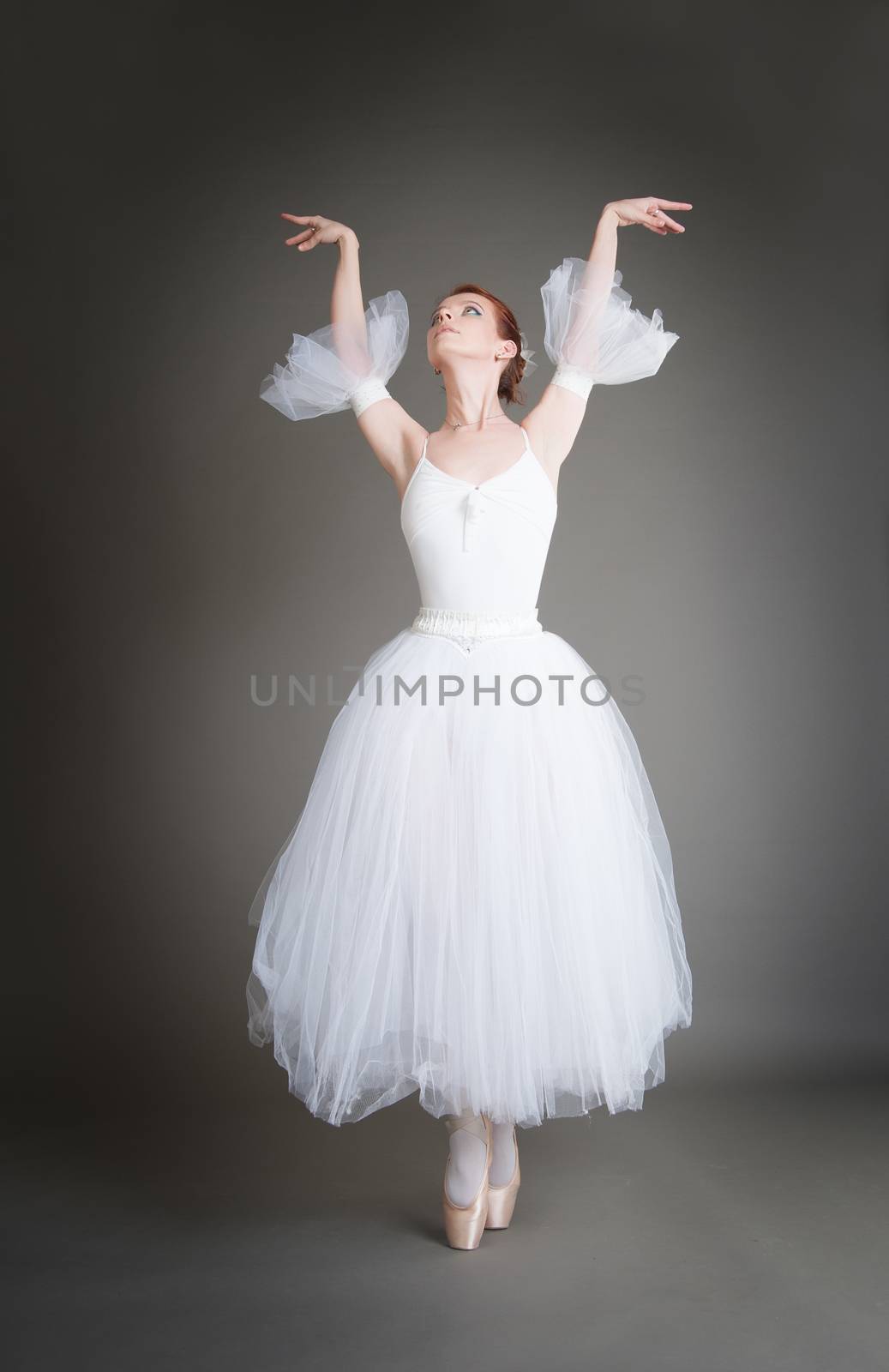 dancer in the white tutu dancing on a grey background