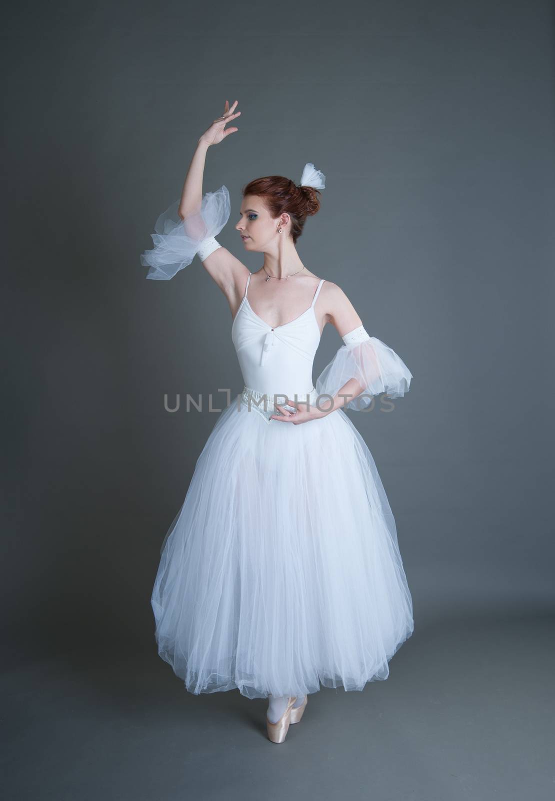 dancer in the white tutu dancing on a grey background