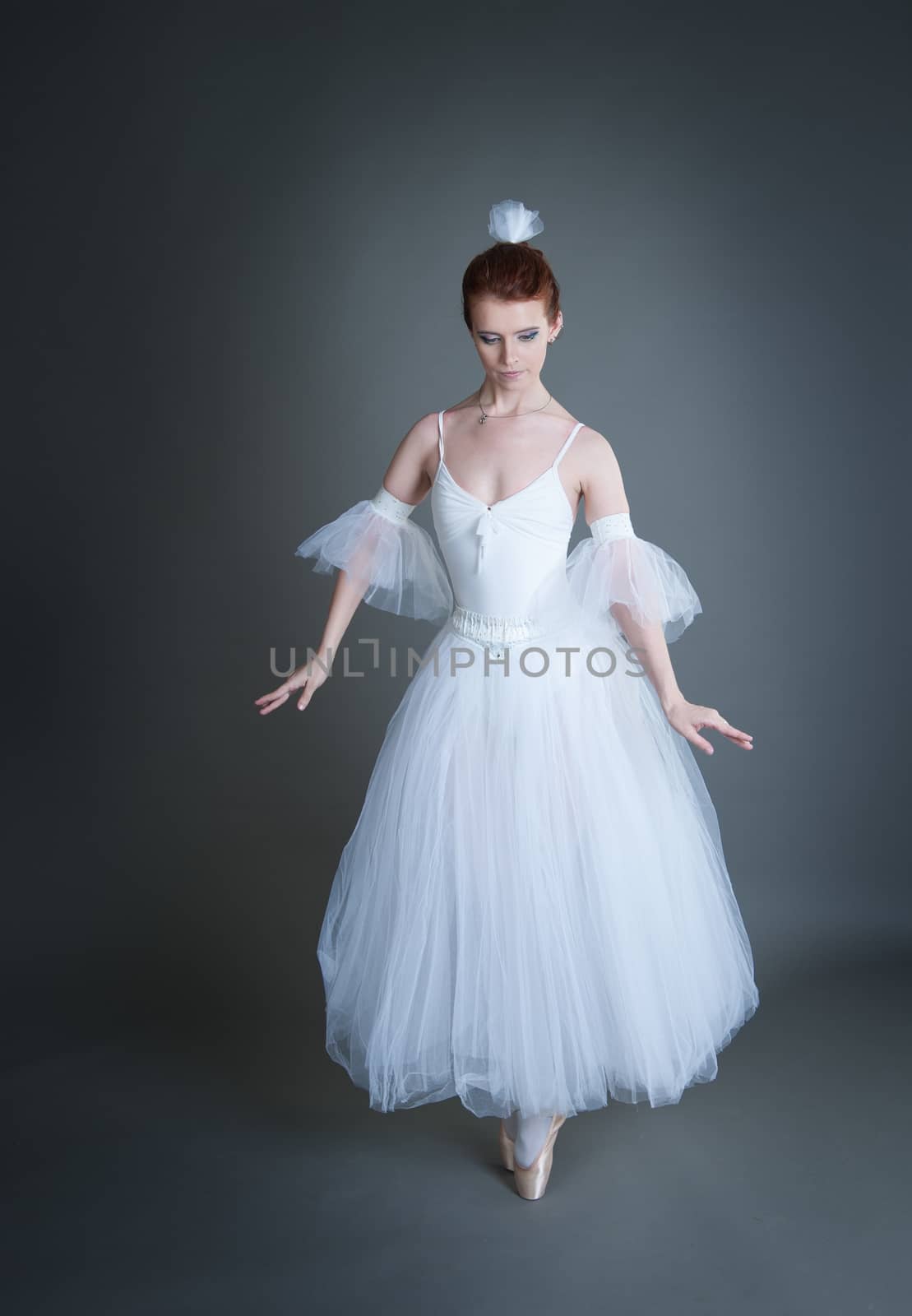 dancer in the white tutu dancing on a grey background