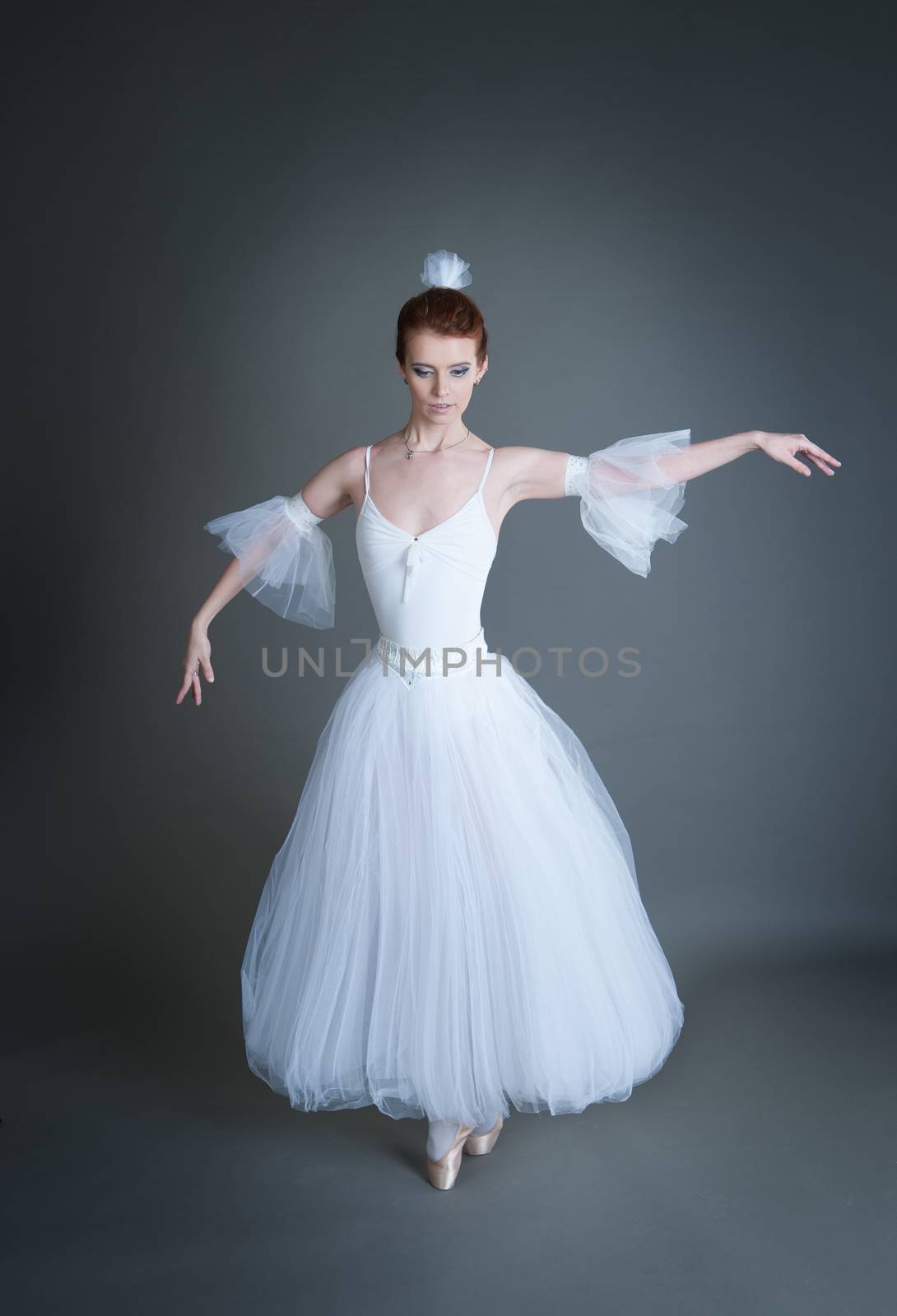 dancer in the white tutu dancing on a grey background