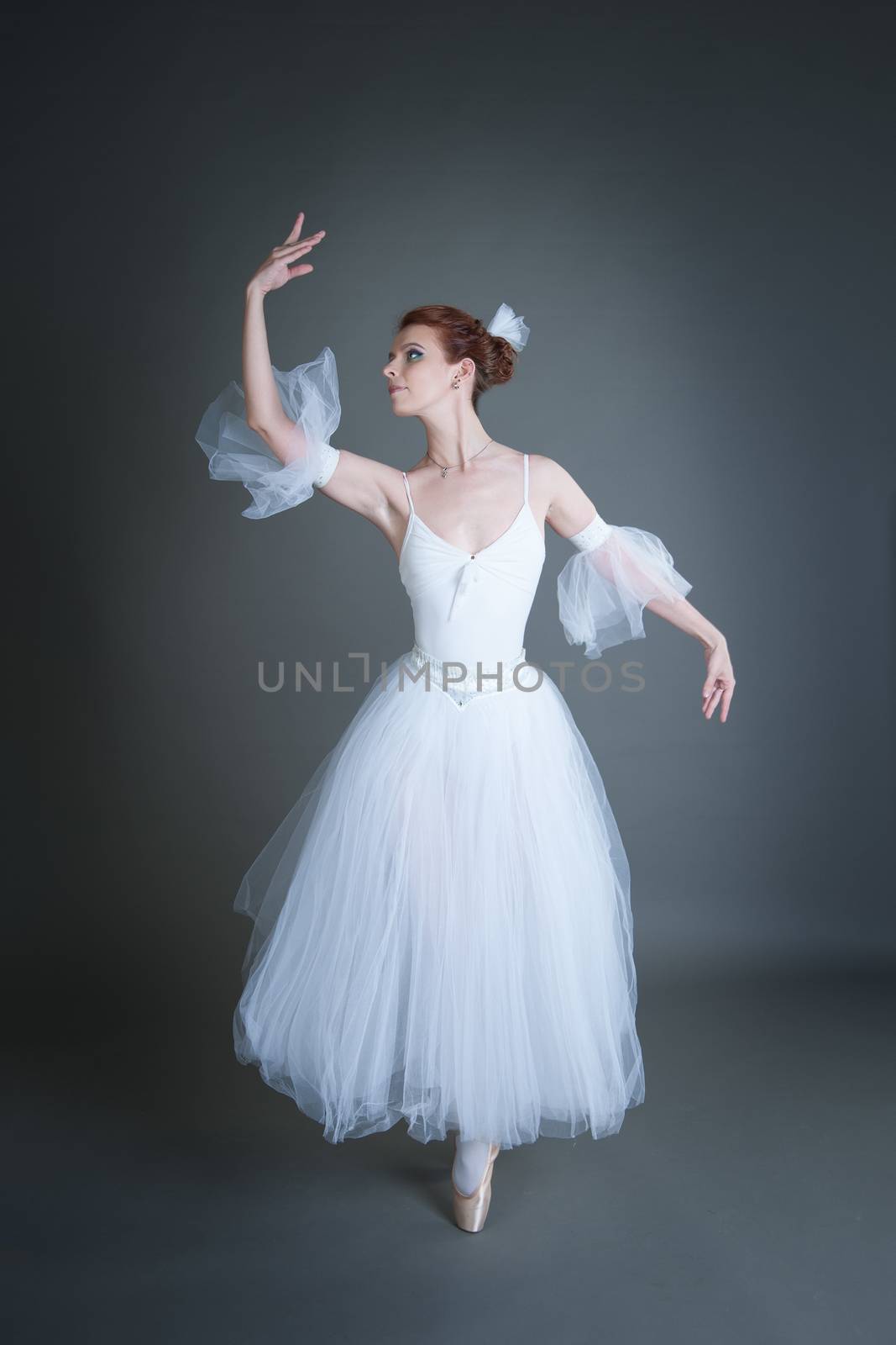 dancer in the white tutu dancing on a grey background