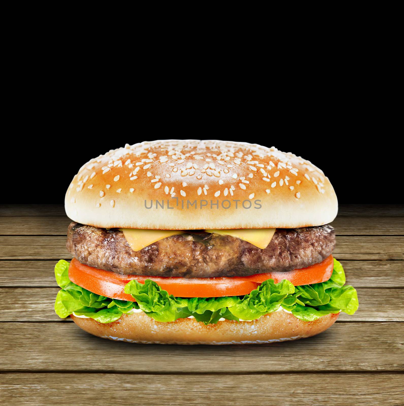 Delicious burger with beef, tomato, cheese and lettuce on wood background