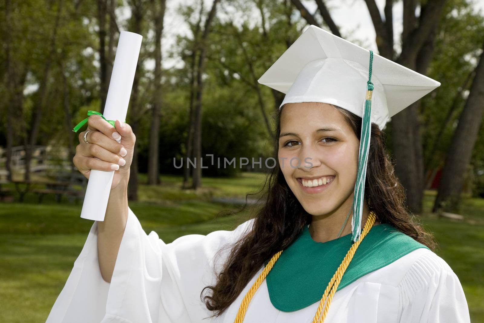 A beautiful, mixed-race student proudly holding up her degree.
