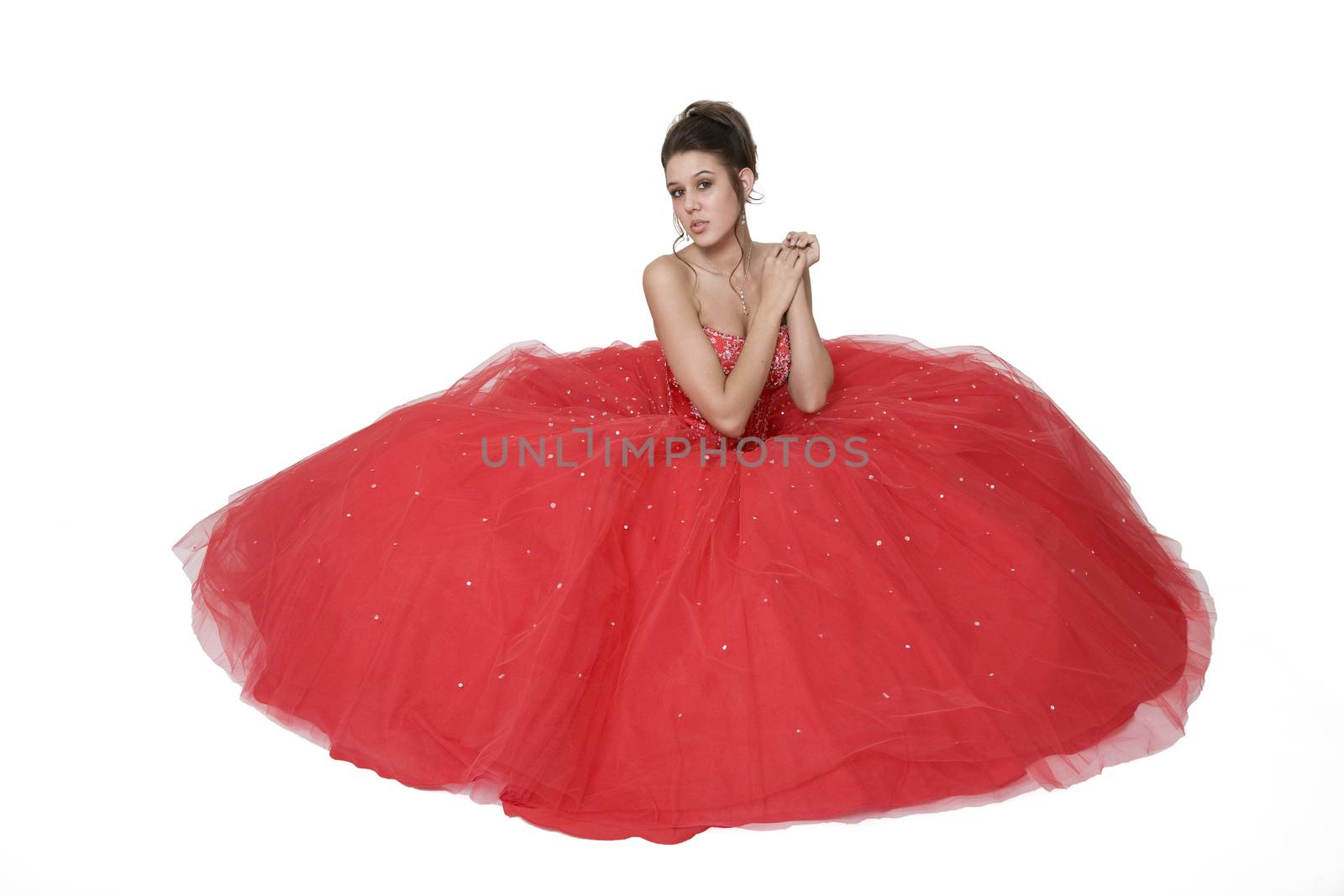 Teenage girl posing in her graduation/prom gown against a white background.