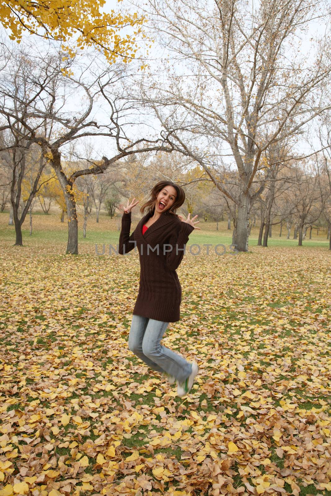 Happy girl jumping for joy.  Focus on face.  Motion blur in feet.