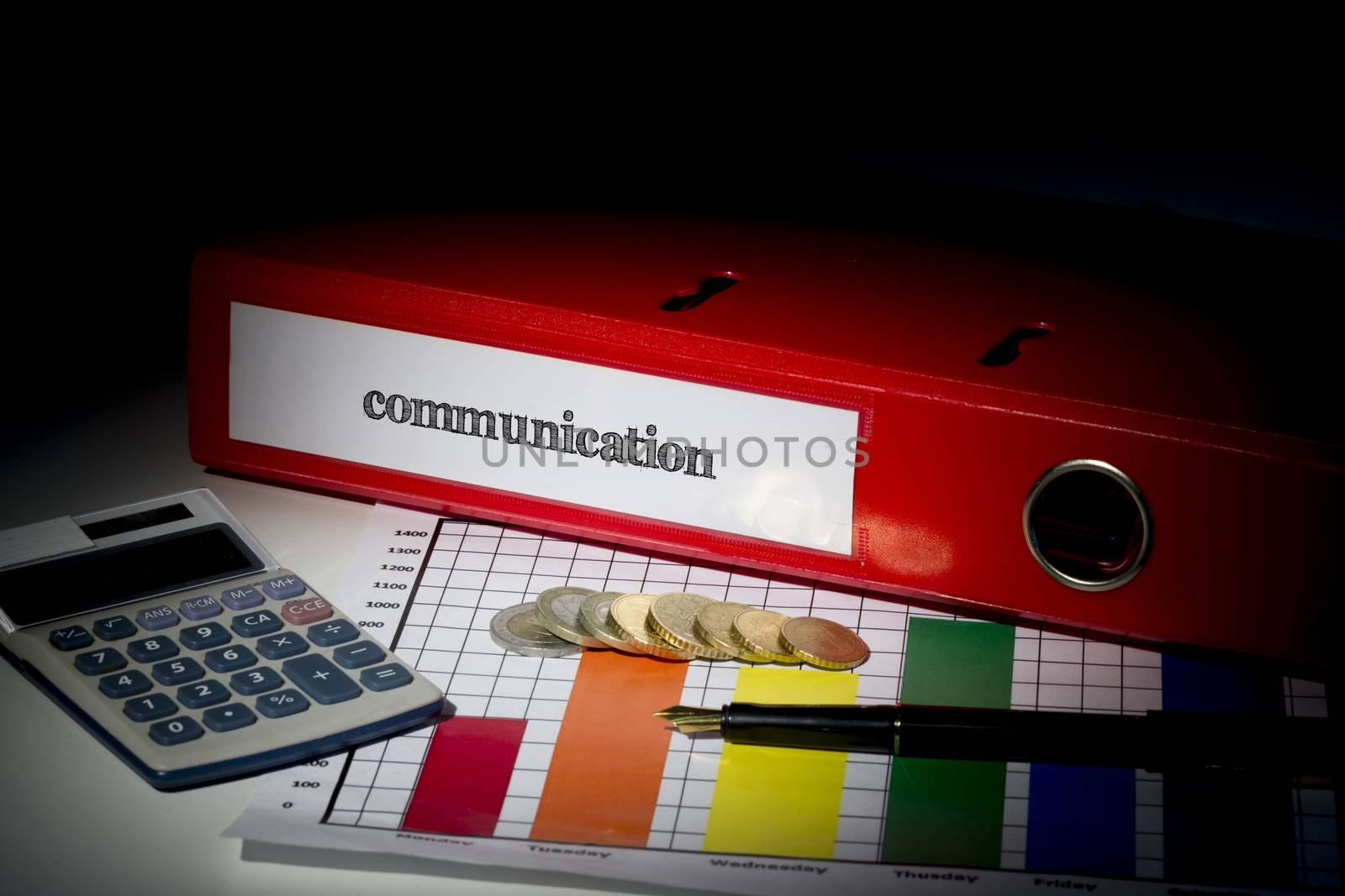 The word communication on red business binder on a desk