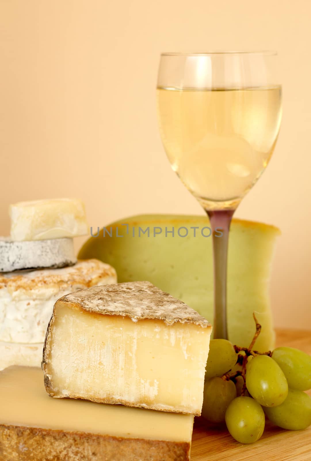 Composition with french wine, cheese and grape on wooden table