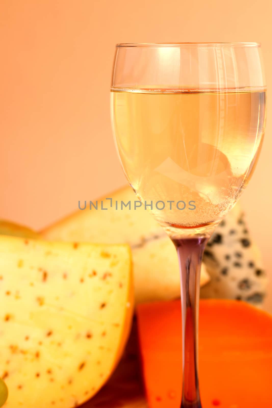 Glass of white wine and cheese composition close-up