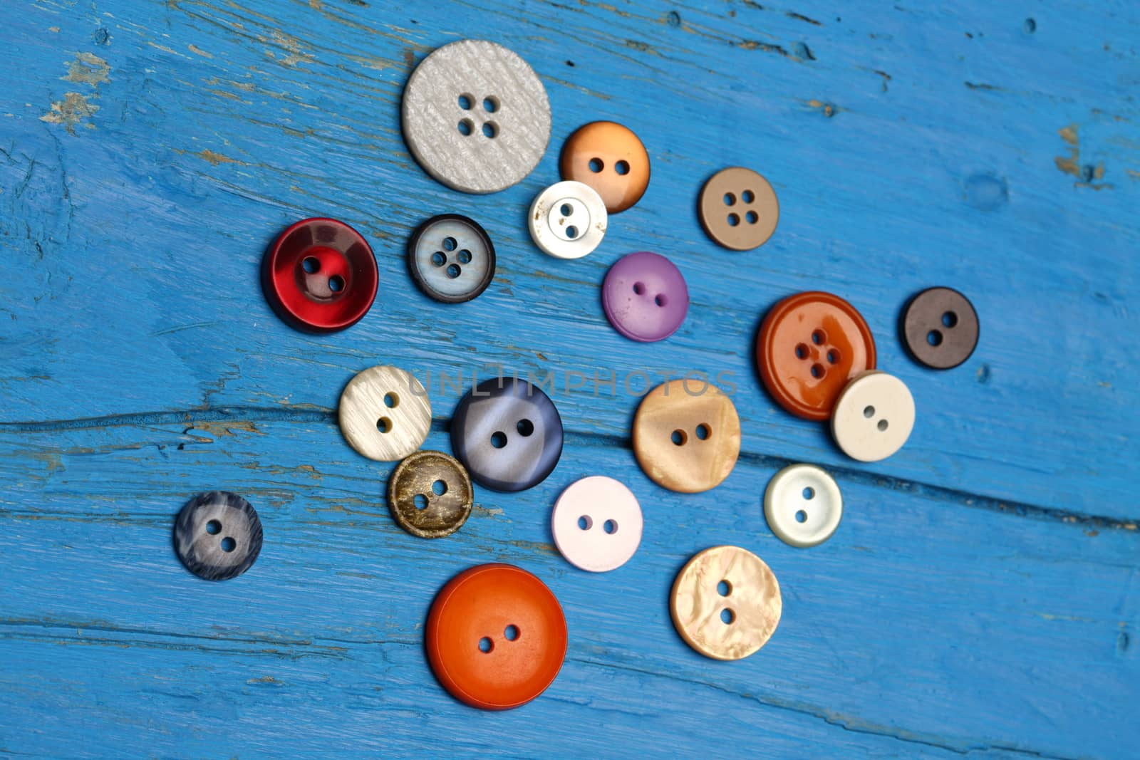 a pile of various colored buttons to sewing 