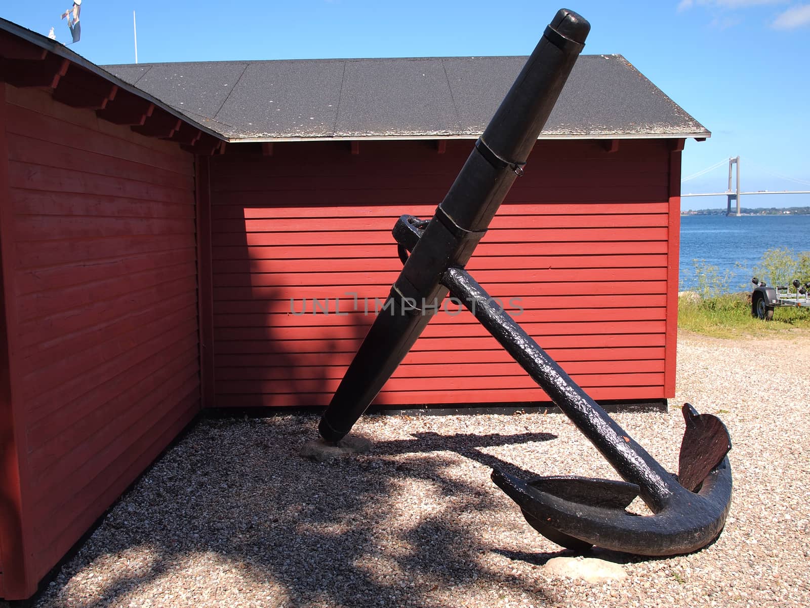  Old iron anchor with ocean in the background                              