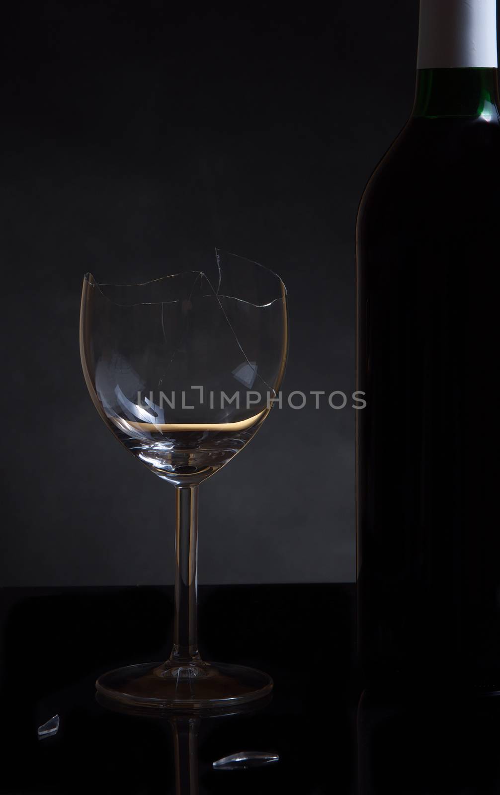 Vine bottle and broken glass on dark background