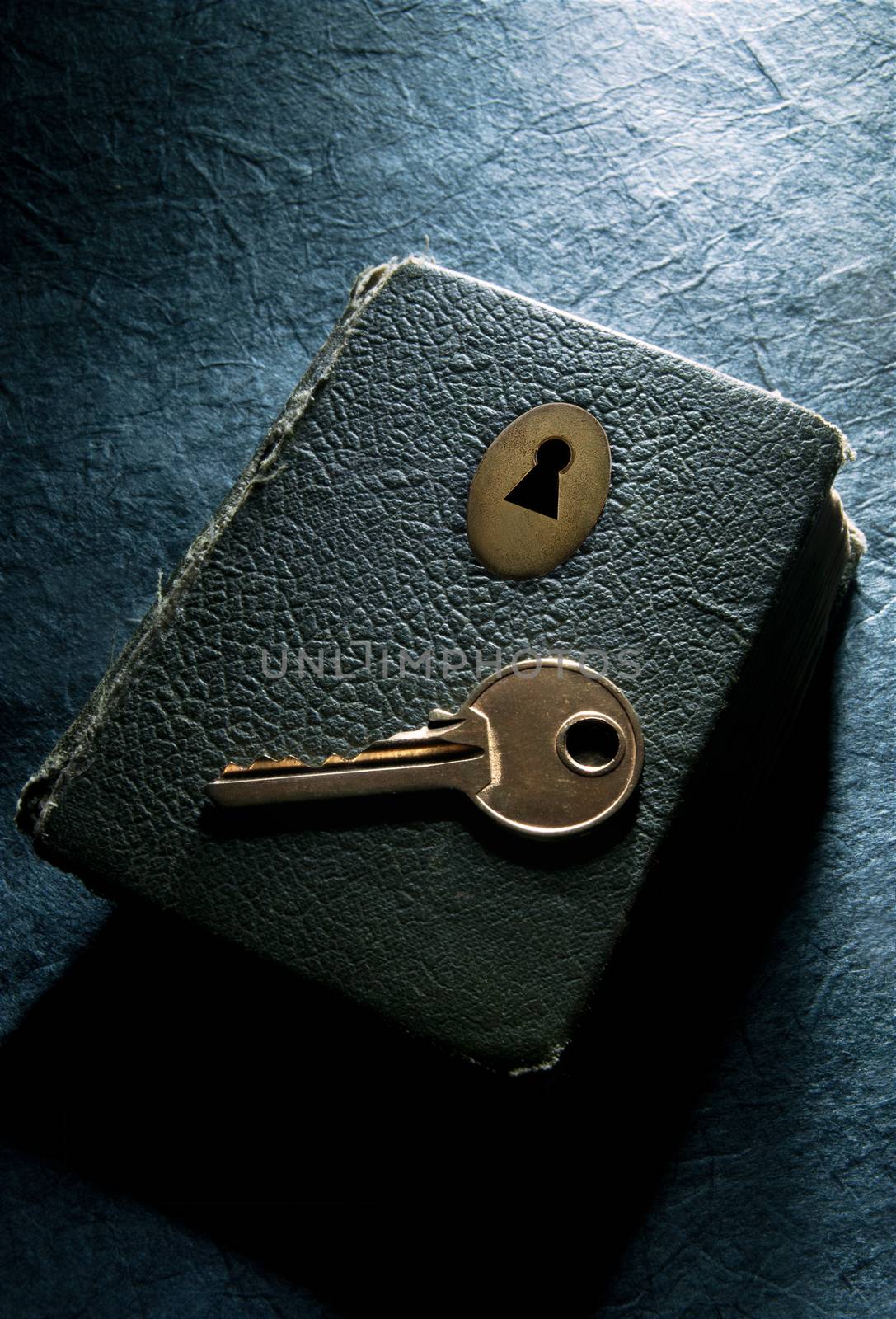 Key on top of an aged book with a lock